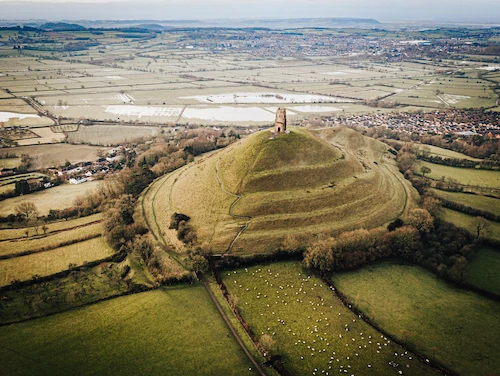 Paisaje agrícola europeo en la Edad Media con campos de cultivo y fortificación feudal