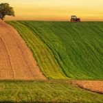 Campo agrícola con tractor, símbolo de la revolución agrícola y la mecanización en la Edad Moderna