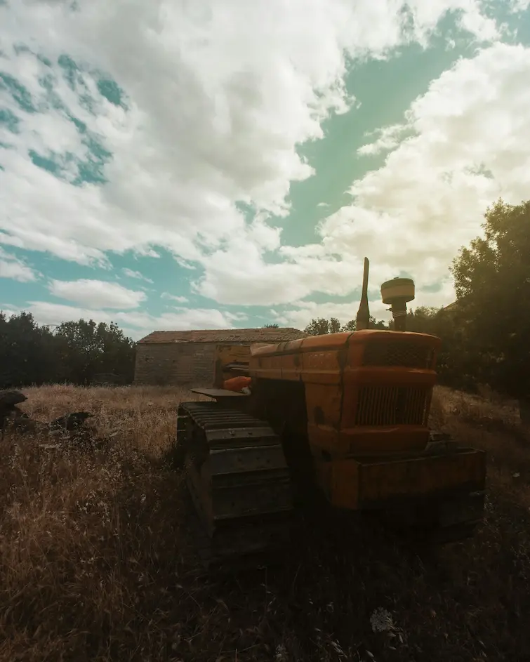 Tractor antiguo en un campo agrícola, símbolo de la mecanización en la revolución agrícola
