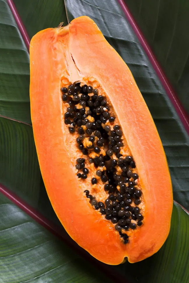 Papaya abierta mostrando pulpa y semillas, representando la calidad comercial y el valor nutricional de la papaya producida en España.